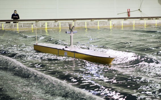 A model ship sails in the Aalto Ice and Wave Tank basin.