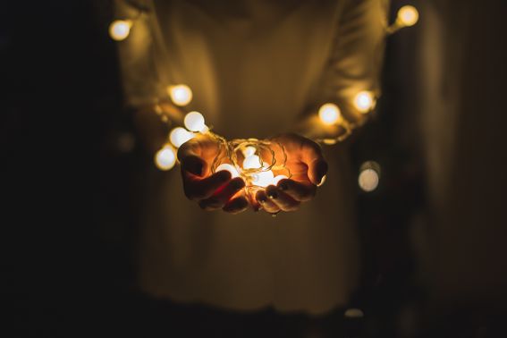 Decorative image, two hands holding christmas lights