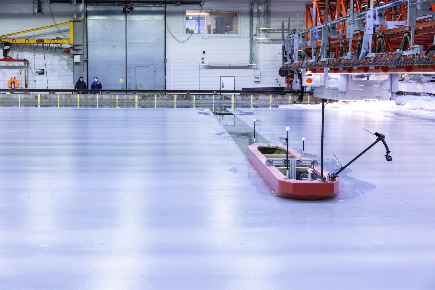 A model ship breaks through the ice in the Ice and Wave Tank. Photo credit: Mikko Raskinen