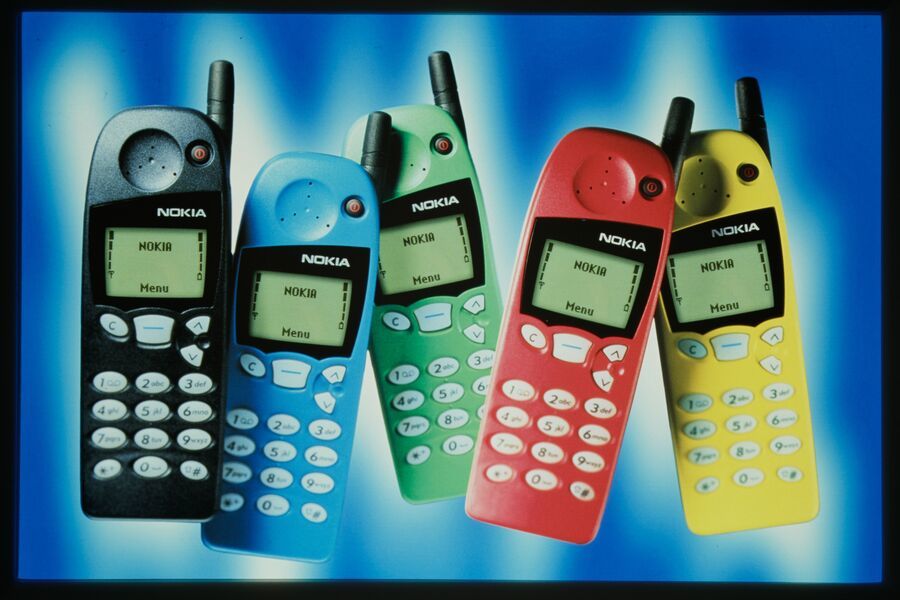 Five Nokia mobile phones in black, blue, green, red, and yellow are displayed against a blue and white background.