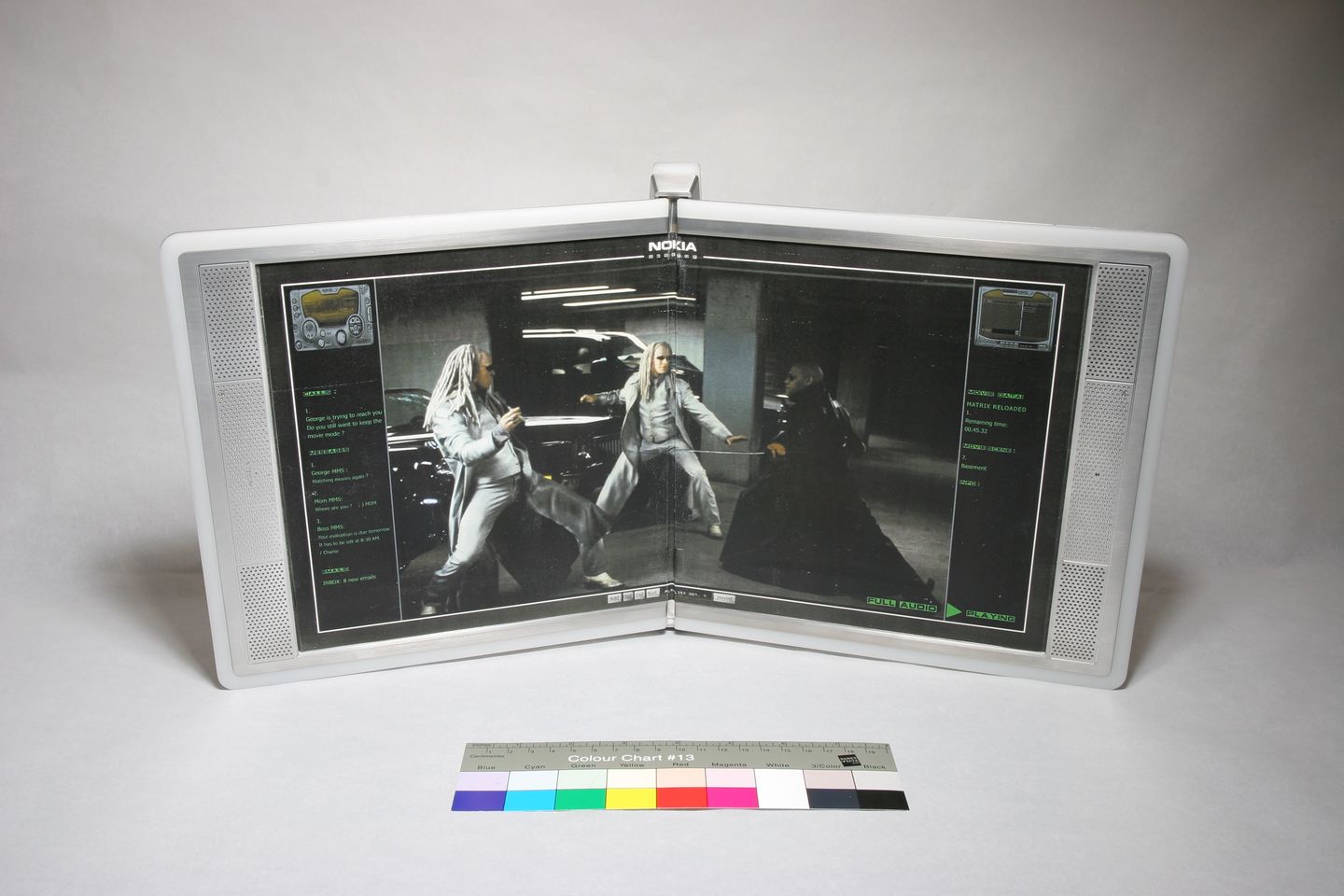 A dual-screen Nokia device displaying a movie scene with two silver-haired characters fighting in a garage.